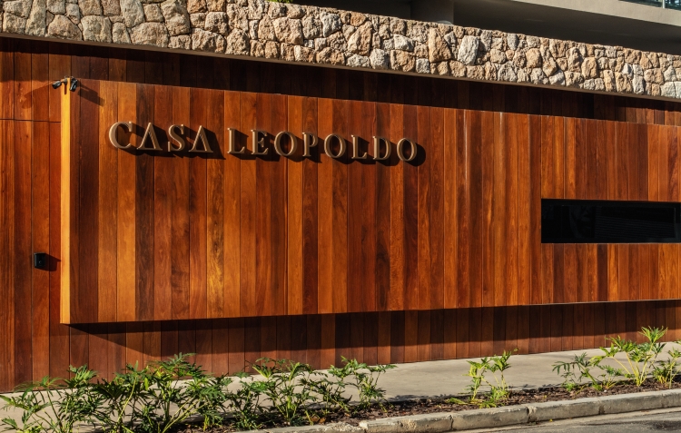 Fachada em madeira e pedra natural com o letreiro do Casa Leopoldo, edifício de altíssimo padrão no Itaim Bibi, em São Paulo