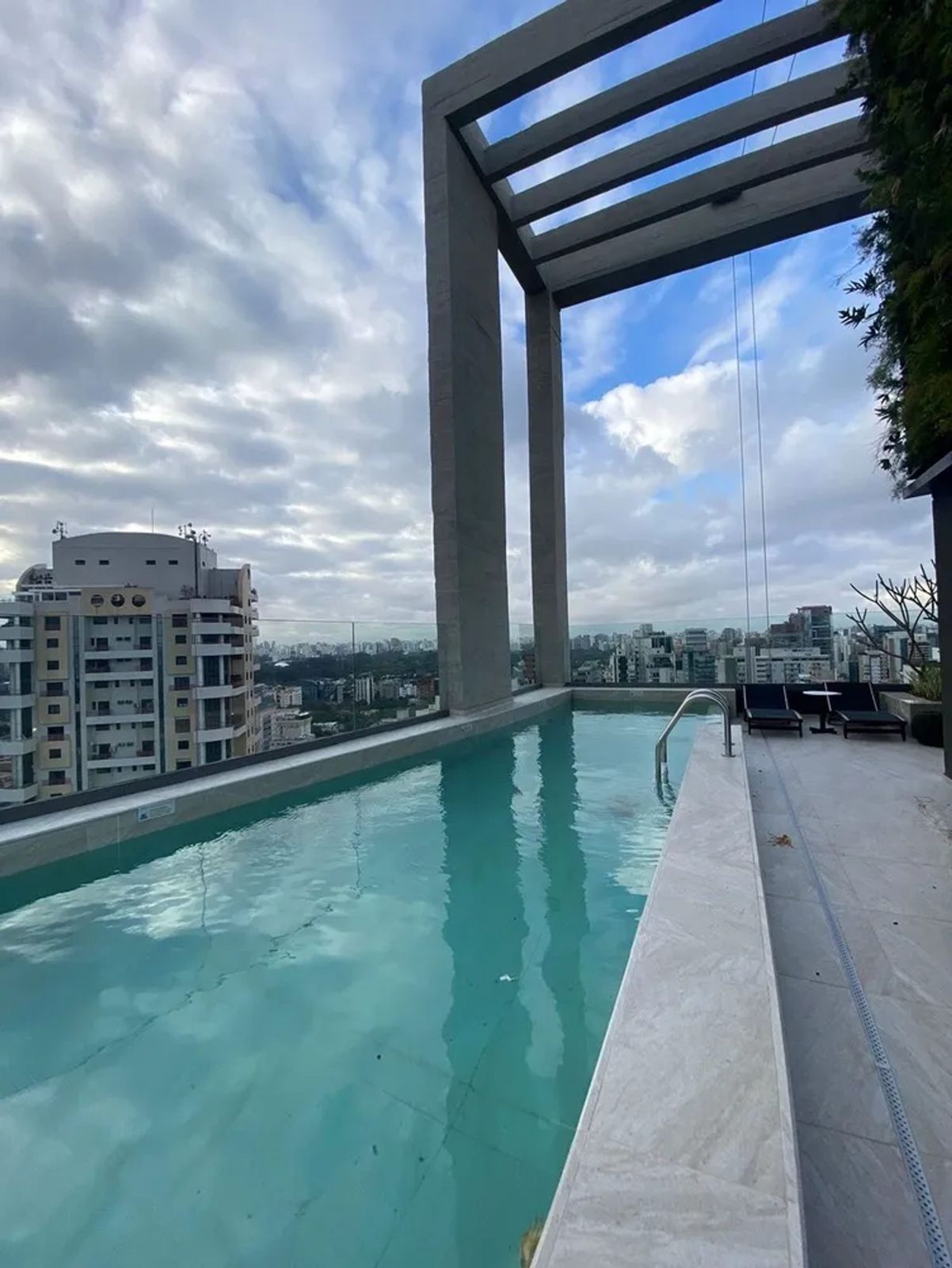 Piscina com pergolado do Oscar Itaim, com vista para o skyline de São Paulo