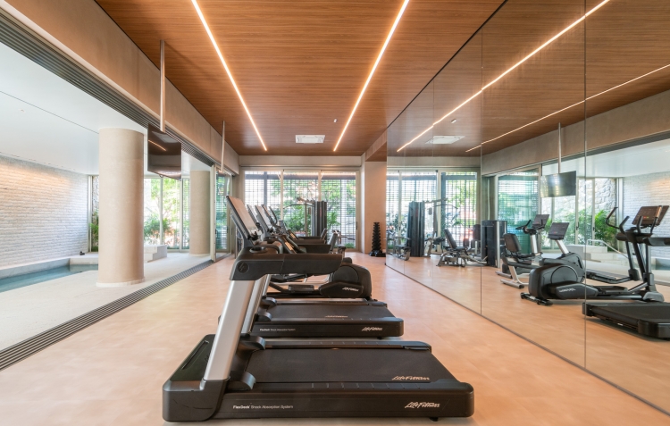 Fitness equipado do Casa Leopoldo, com esteiras, espelhos e vista para a piscina, em São Paulo