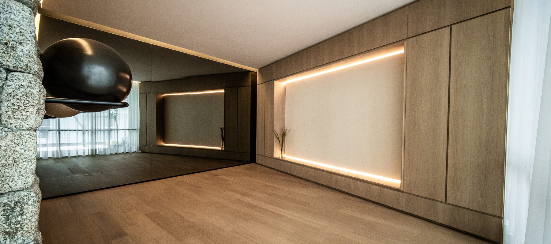 Sala multiuso do Casa Brasileira Itaim, com marcenaria e iluminação embutida