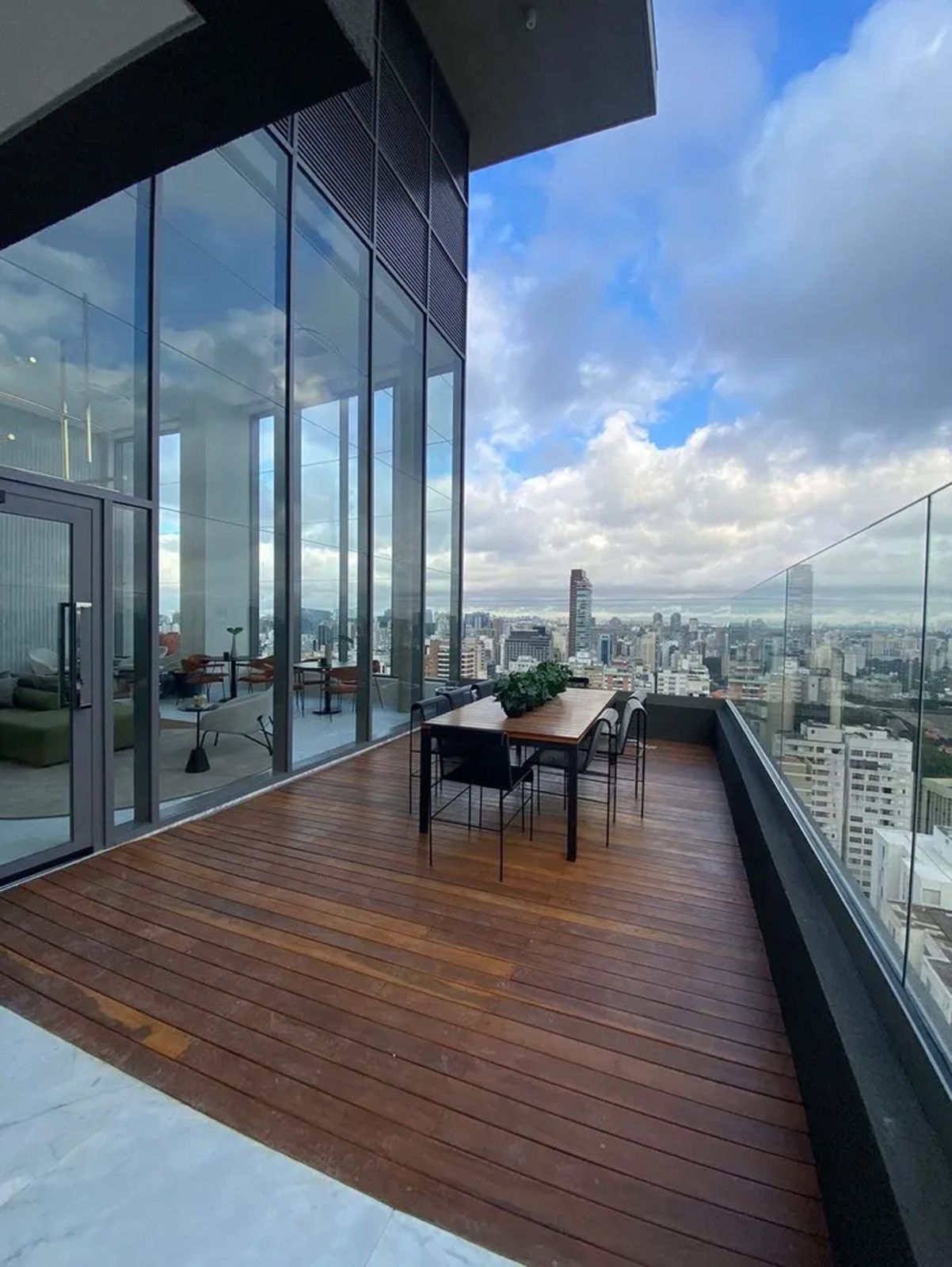 Terraço com deck de madeira do Oscar Itaim, com vista desimpedida para o verde dos Jardins