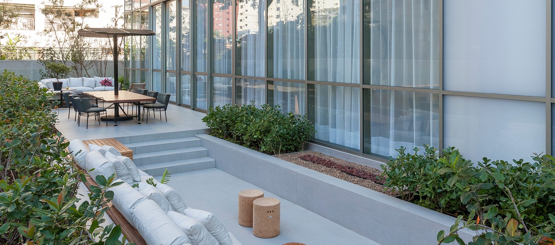 Lounge externo com fire place do Casa Brasileira Itaim, integrado ao paisagismo