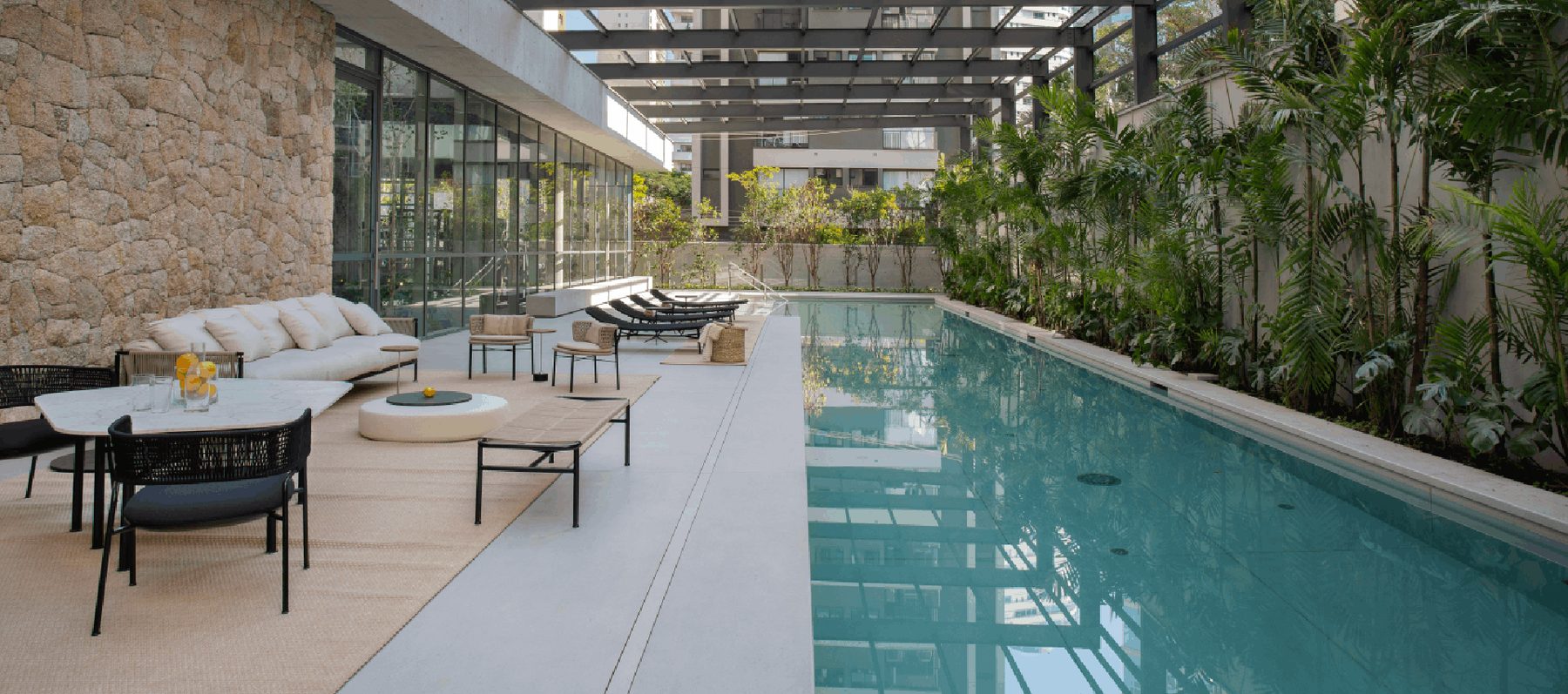 Piscina com raia de 25 metros do Casa Brasileira Itaim, cercada por vegetação nativa